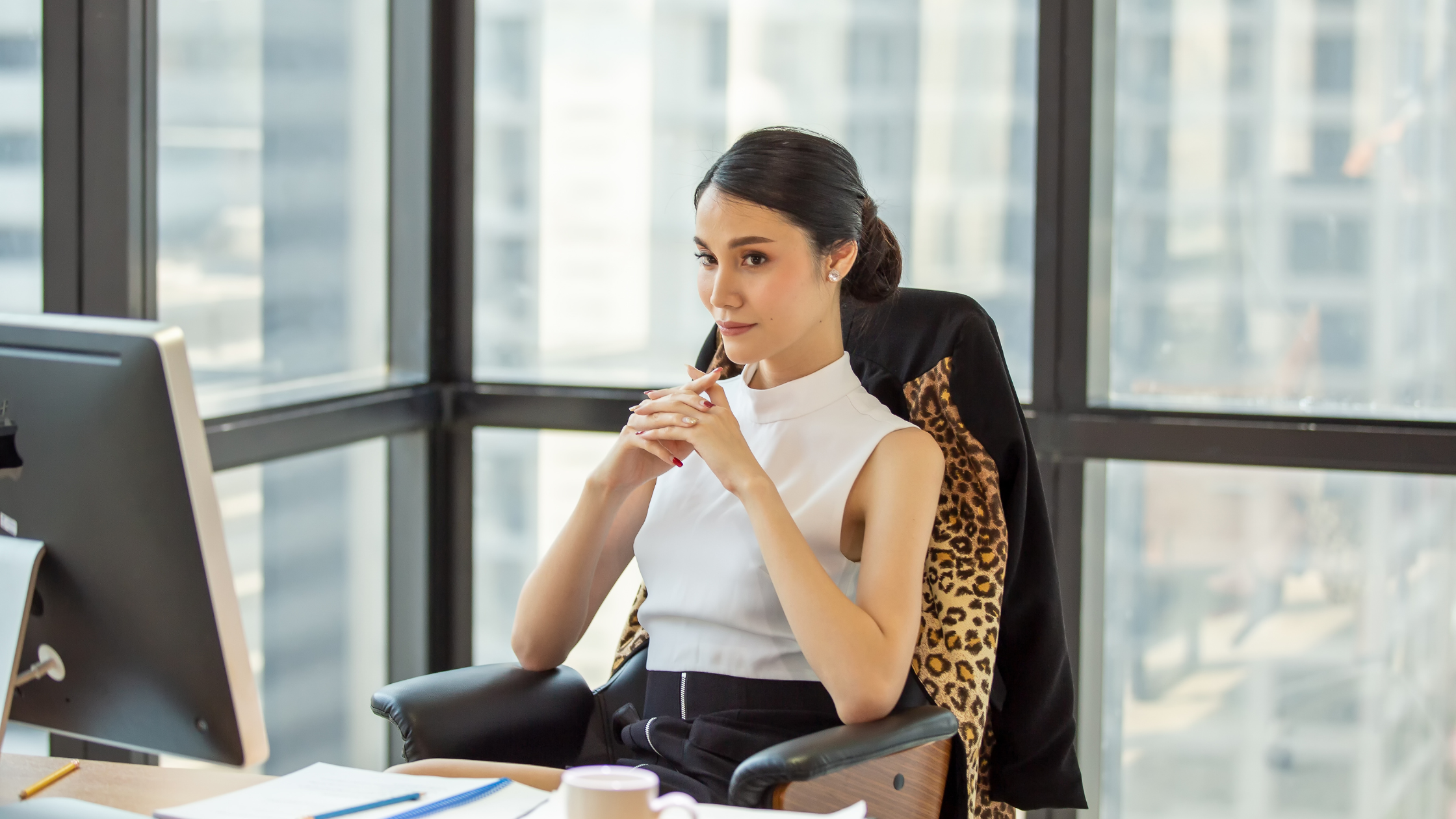 Women power pose at desk